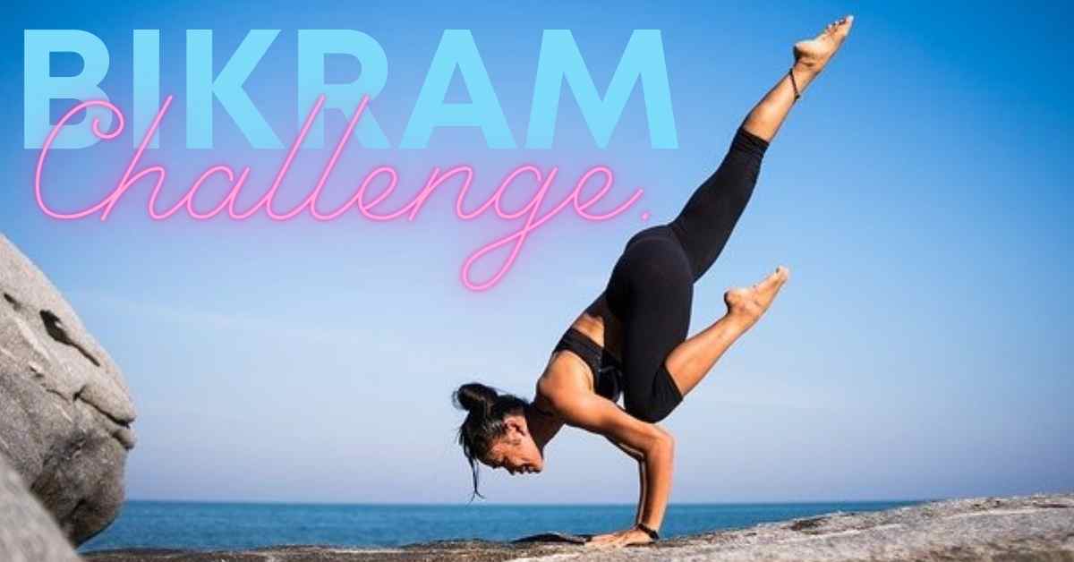 woman wearing black yoga pants and a black sports bra, practicing bikram yoga  hand stand by the sea.